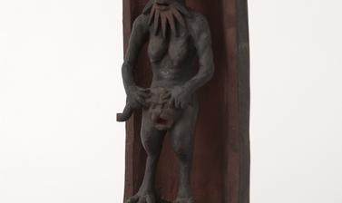 Small statue of a human-type figure with a beard, breasts, bird-like legs.
