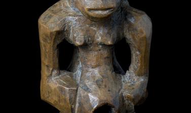 Wooden statue with breasts and a penis.